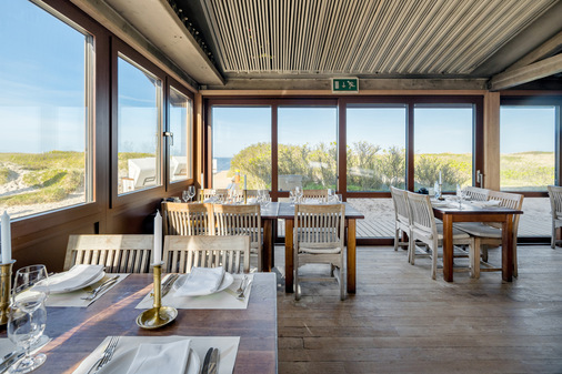 Filigrane, großflächige Fensterprofile aus Aluminium ermöglichen einen ungehinderten Ausblick auf die schöne Küsten- und Dünenlandschaft der Nordseeinsel Sylt. - © Schüco International KG