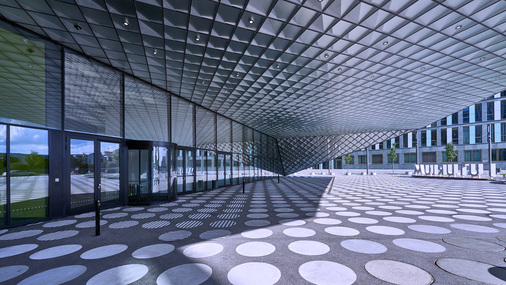 Die reflektierenden transluzenten und transparenten Fassaden-Oberflächen ziehen sich auch in das Innere des Eingangsbereichs hinein. - © Arup / Rossmann

