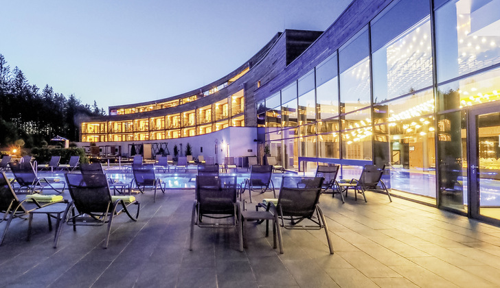 Ein Blick auf die gläserne Fassade des Hotels Rischlhof, die mit ihren Neutralux Gläser von Isolar für ein gutes Innenraum­klima sorgt. - © Foto: Hotel Reischlhof
